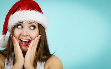 Surprised woman in santa claus hat