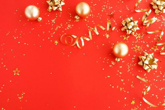 christmas or new year decorations background in gold colors on red  background with empty copy space for text. holiday and celebration concept for postcard or invitation. top view 