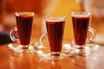 Three glasses of red hot drink. Mulled wine or tea. Warm atmosphere