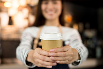 Young asian women barista hold coffee cup serving a client at the coffee shop,start up small business owner food and drink concept..