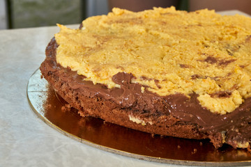 Cooking homemade cake. One sponge cake with a layer of chocolate cream and a layer of orange cream on a light background. Close-up