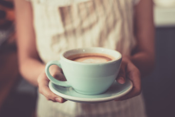 Young asian women barista hold coffee cup serving a client at the coffee shop,start up small business owner food and drink concept..