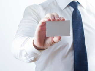 Hand holding white business card on white background