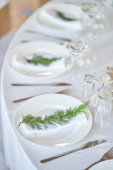 Wedding decorations. White plates on a white tablecloth. Natural style wedding