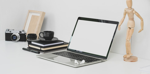 Professional photographer workplace with open blank screen laptop, camera and office supplies
