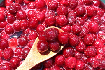 Red cherry with sugar and wooden spoon