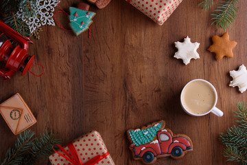 Christmas gingerbread cookies on a wooden background with aromatic coffee and cinnamon sticks