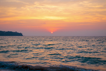 sunset on the sea. sandy beach, clear water, waves. surf line in the warm colors of the setting sun.