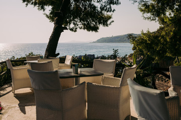 wicker chairs and tables in a summer cafe with sea views. Restaurant sea terrace