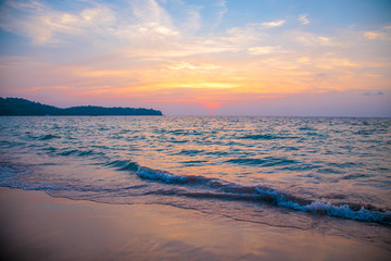 sunset on the sea. sandy beach, clear water, waves. surf line in the warm colors of the setting sun.