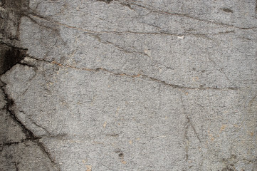 Rough textured stone surface with cracks, closeup