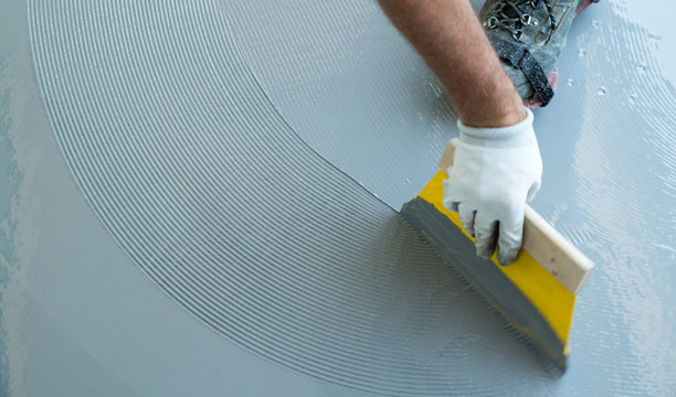 Construction Worker Renovates Balcony Floor And Spreads Watertight Resin And Glue