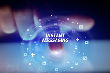 Finger touching tablet with social media icons and INSTANT MESSAGING