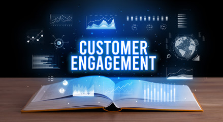 CUSTOMER ENGAGEMENT inscription coming out from an open book, creative business concept