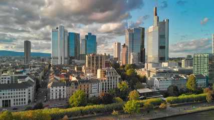 Fototapeta premium Aerial flying along the futuristic skyline the business and financial centre of Frankfurt am Main, sunset view from drone