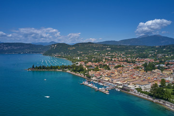 Fototapeta na wymiar Aerial photography. Beautiful coastline. In the city of Bardolino, Lake Garda is the north of Italy. View by Drone. Docked yachts parking in Port.