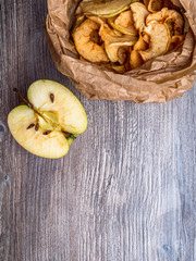 Tasty apple chips in paper bag on wooden table, Healthy snack of apples Diet dish. Space for copy