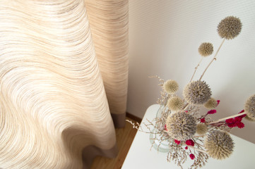 Interior set up with dry plants in natural sand and earth tones and matching beige curtains