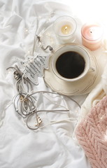 Fflat lay Christmas background in hygge style. cup of coffee, candles, warm plaid and New Year decoration. Winter holiday concept.Home working cozy lifestyle in a bed.