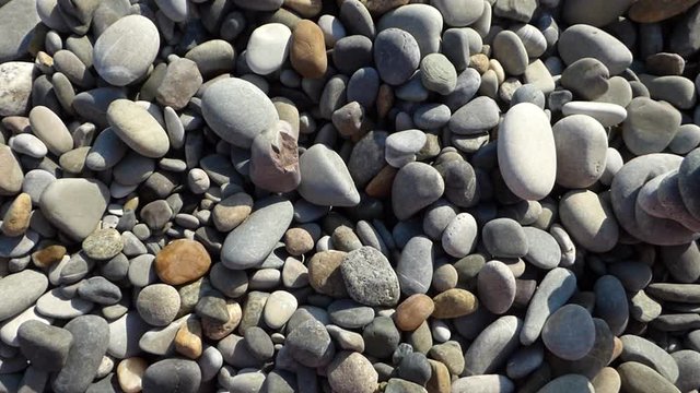 Top view of pebbles with Zen stone tower on the beach. Tranquility and disturbance concept. Sunny summer evening at Black sea coast.