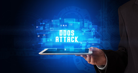 Young business person working on tablet and shows the digital sign: DDOS ATTACK