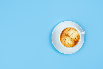 One white espresso Cup on a blue background.