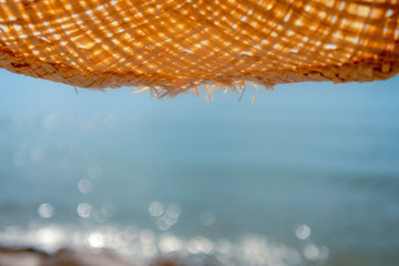 View from under a straw hat to the sea. Background.