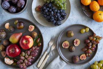 healthy organic fruits in plates apple grapes fig plums tangerines