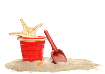 Beach toys for kids, plastic tools in sand pile with seashells isolated on white background