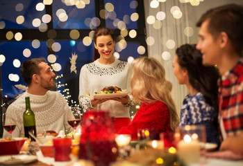 Obraz na płótnie Canvas holidays and celebration concept - happy friends having christmas dinner at home