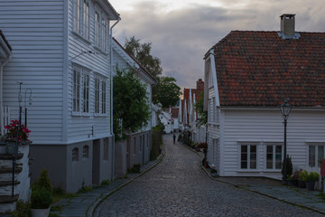 Traditional wooden houses in Gamle Stavanger. Gamle Stavanger is a historic area of the city of Stavanger in Rogaland, Norway. Beautiful summer sunset with coloured sky. July 2019