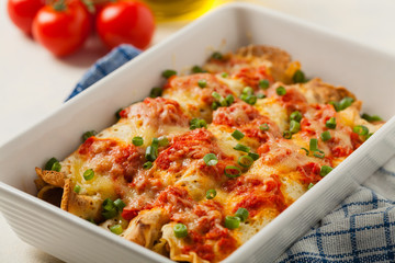 Baked pancakes with chicken in tomato sauce.