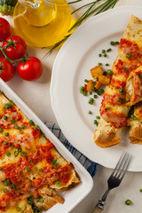 Baked pancakes with chicken in tomato sauce.