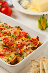 Baked pancakes with chicken in tomato sauce.