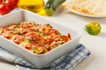 Baked pancakes with chicken in tomato sauce.