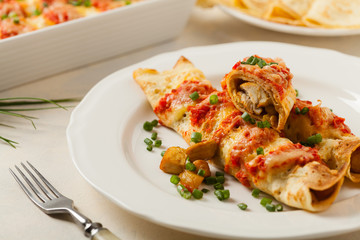 Baked pancakes with chicken in tomato sauce.