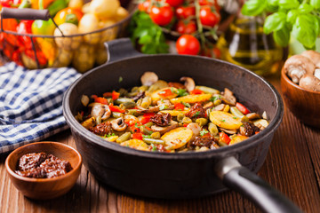 Fried pan vegetables, with mushrooms and dried tomatoes. Seasoned with a mix of herbs.