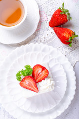 Homemade cake, Strawberry Shortcake on white plate with tea and decorated with strawberries giving the feeling of the morning atmosphere.