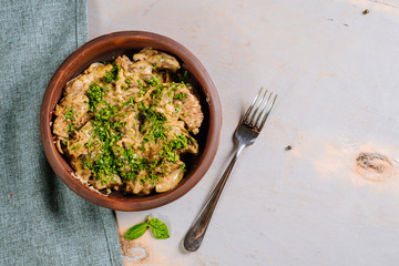 Dish of liver with herbs on the wooden background
