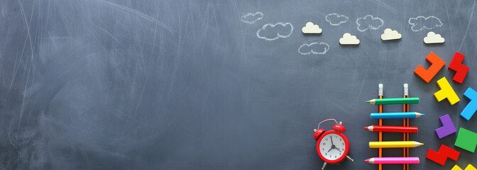Education concept of Ladder made from pencils next to clouds over blackboard