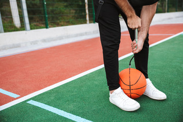 Close up of a sportsman pumping basketball ball