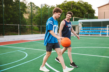 Obraz premium Two smiling confident basketball players walking