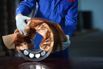 The worker manually packs the finished bearing. Bearing production concept. Photo in the interior...