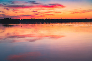 Naklejka na ściany i meble Very romantic, full of orange and beautiful sunset on the lake, before forrest, Finland