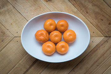 fresh and ripe orange mandarins in a white plate