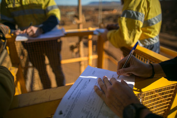 Rope access miner supervisor sigh of JSA risk assessment permit to work on site prior to performing high risk work on construction mine site, Perth, Australia  - obrazy, fototapety, plakaty