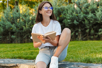 Smiling young girl reading a book