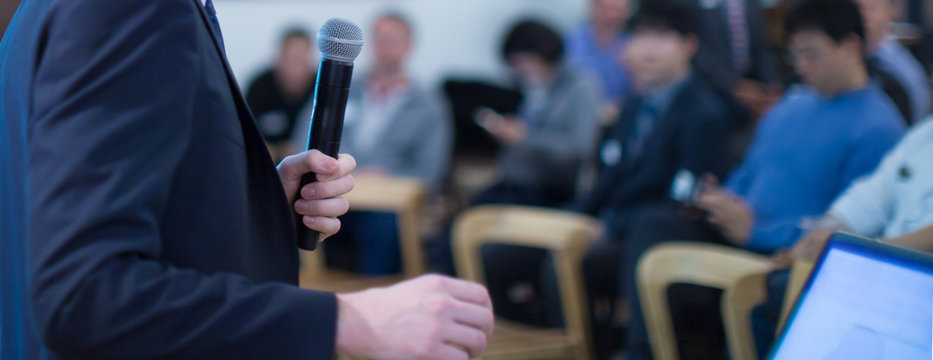 Tech speaker giving seminar to audience. Entrepreneurs in development workshop listen to presenter. Executive manager giving speech in conference hall. Technology executive in professional lecture.