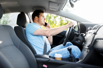 transport, vehicle and people concept - smiling man or driver driving car and calling on smartphone