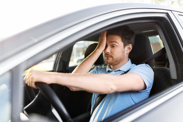 transport, vehicle and driving concept - tired sleepy man or car driver rubbing eyes